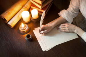 Woman writing at a desk by candlelight with a feather pen