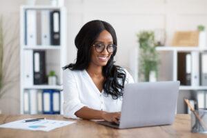 Business woman sitting at working at computer desk in home office