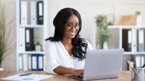Business woman sitting at working at computer desk in home office