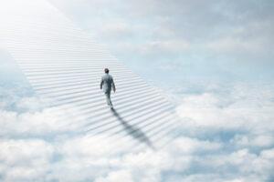 Ethereal sky with staircase and a business man walking up