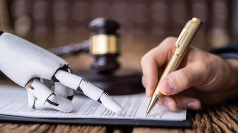 Robot hand and human hand signing in front of a gavel.